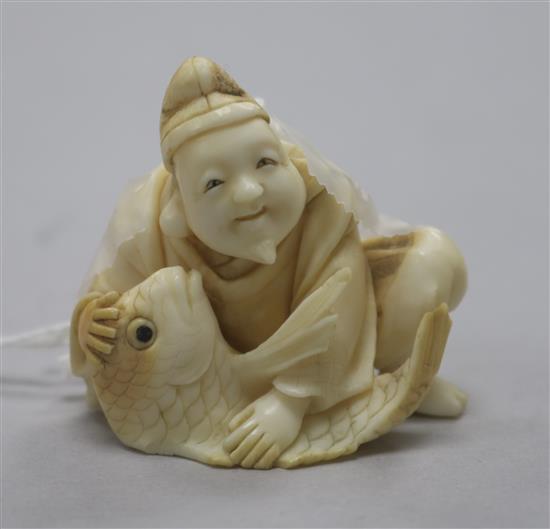A carved ivory netsuke of a man with fish